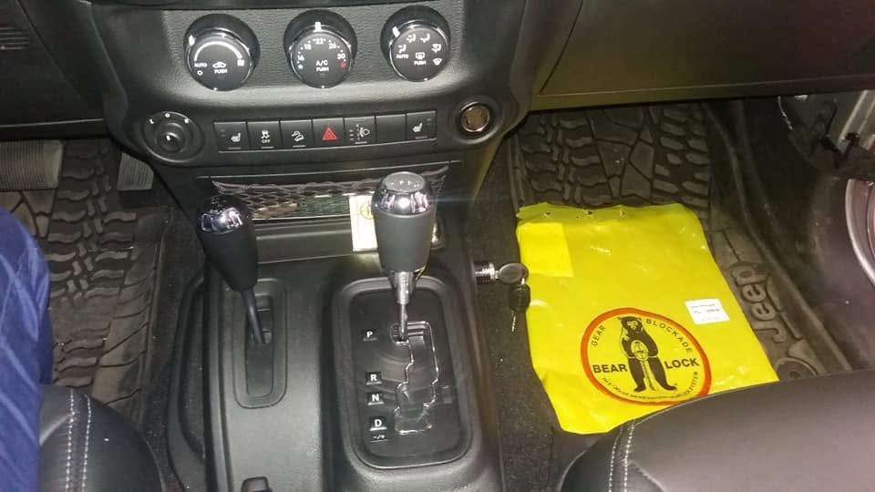 Blocca-cambio Bear-Lock montato sul cambio automatico di una Jeep, con la busta gialla Bear-Lock sul sedile