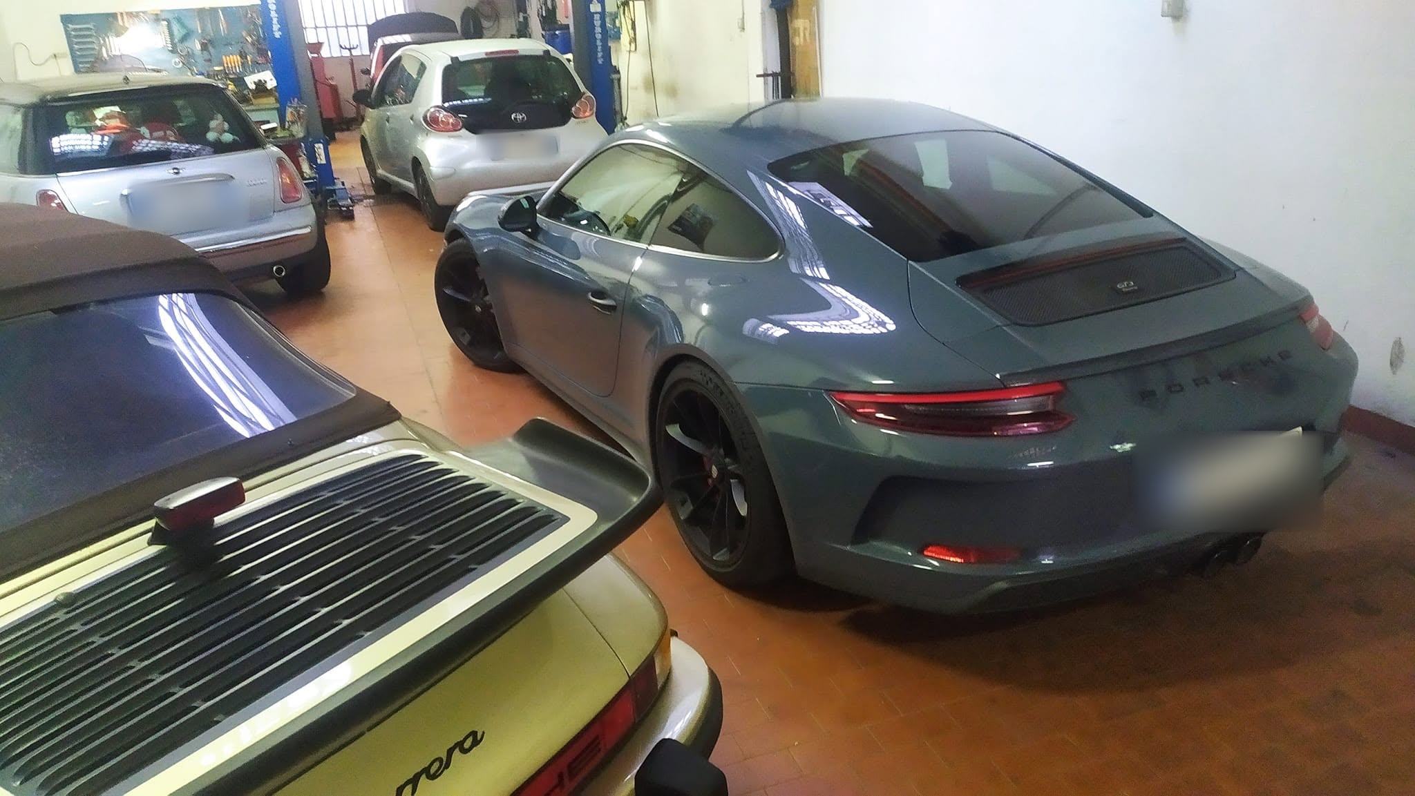 L’officina di via Termopili 25: una Porsche moderna e le classiche dei clienti fianco a fianco
