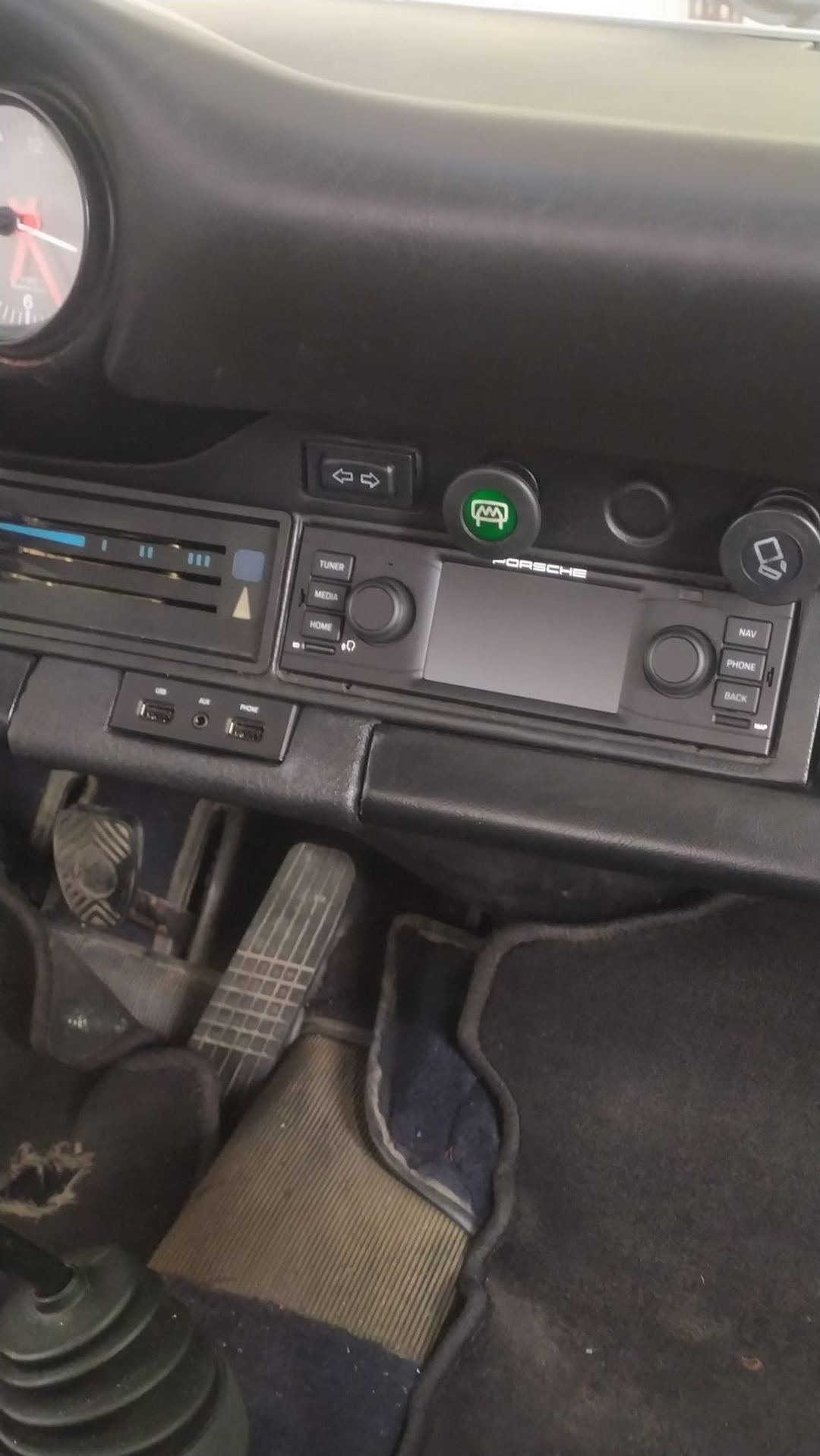 Autoradio moderna con navigatore montata nella plancia di una Porsche 911 classica